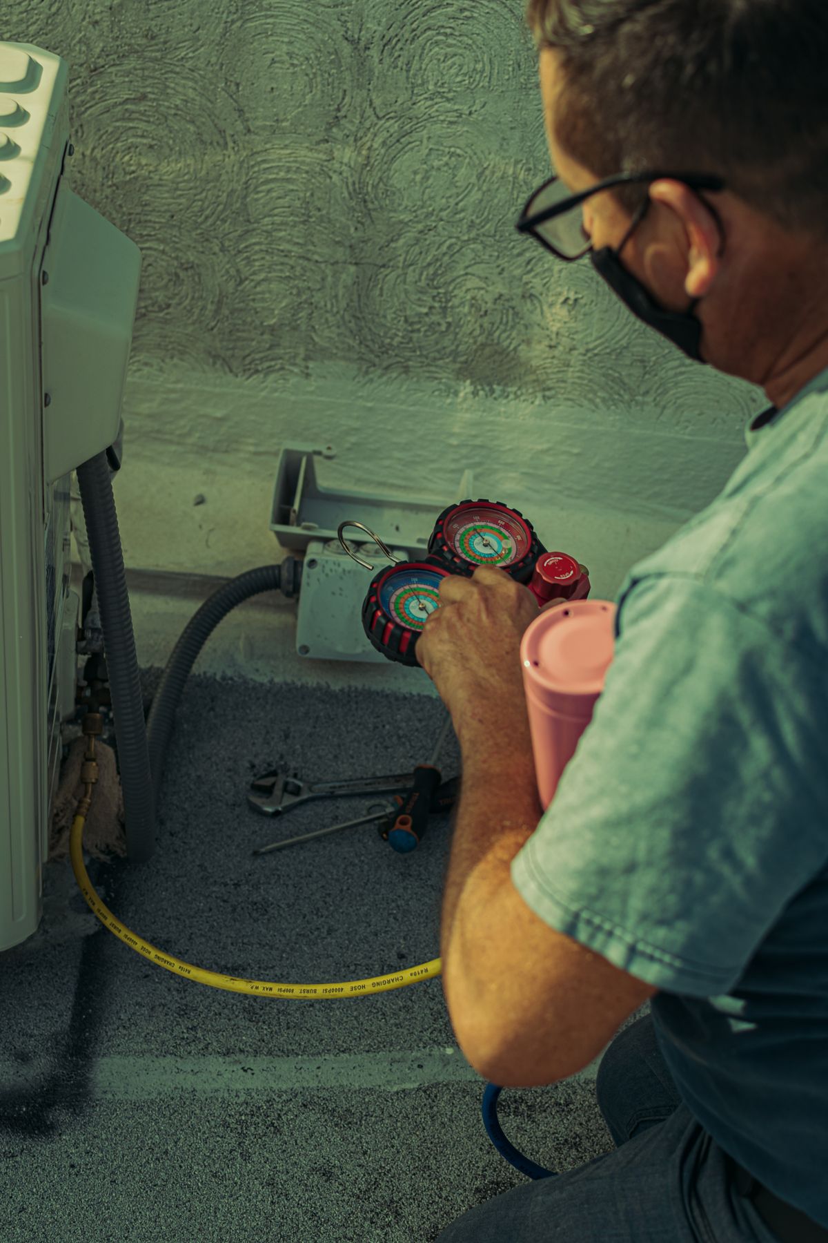 HVAC technician repairing an outdoor AC condenser unit in Glastonbury CT -- Express Home Services
