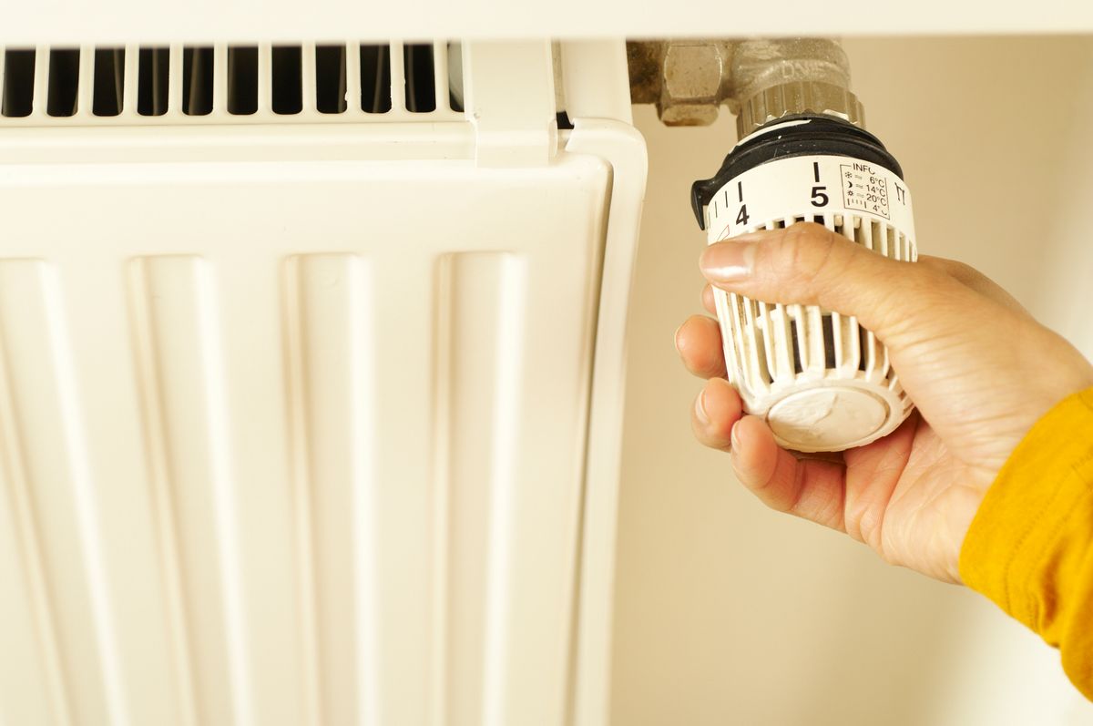 Hand adjusting a radiator thermostat for heating service in a Meriden CT home -- Express Home Services