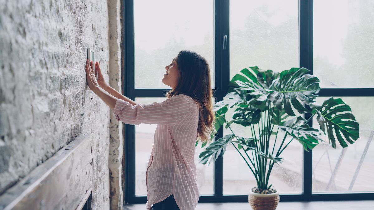 Homeowner installing a smart wall thermostat in a Connecticut home -- Express Home Services